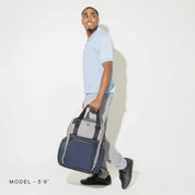 Travelpro Altitude™ Medium Expandable Laptop Backpack 25-30L showing man carrying backpack in his arm