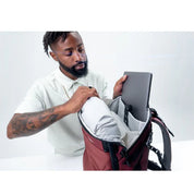 Matador GlobeRider35 Travel Backpack - Garnet man putting laptop computer in sleeve compartment inside bag
